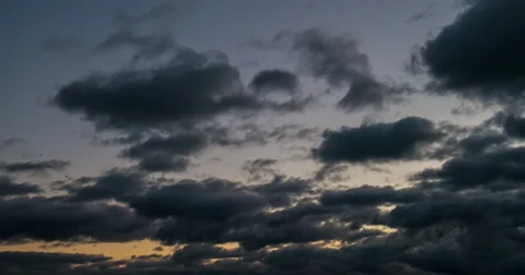 Dark clouds covered the sky. Clouds are flying towards sunset. 4K 動画素材 57484122