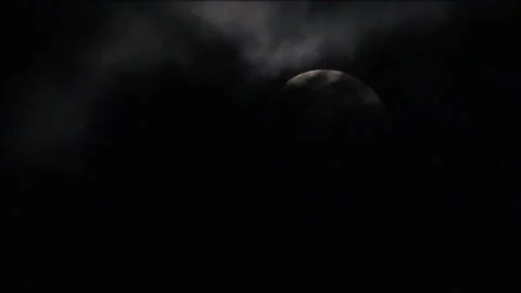 Dark clouds covering a full moon, light from the moon illuminating thinner 스톡 동영상 130227792
