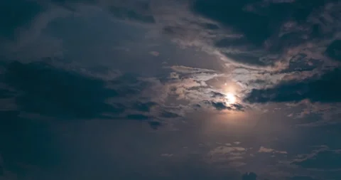 Dark clouds floating fast on bright full moon surface at night sky. Timelapse 4k Stock Footage 197329825