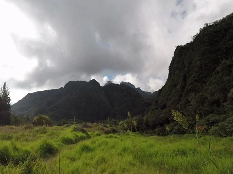 Dark clouds floating over grassy landscape and green mountains Stock Footage 81239207