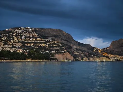 Dark clouds forecast, Storm clouds swirl above shimmering bay as sailor Stock Photos