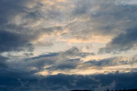 Dark clouds forming during sunset over natural landscape Photos