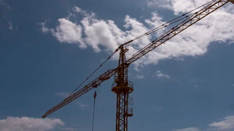 Dark clouds gather above a sliding construction crane. Hyperlapse shot Video stock 132675013