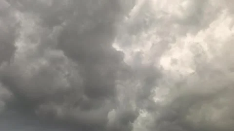Dark clouds gather over a city as a storm approaches in the evening sky with fla Stock Footage 335405904