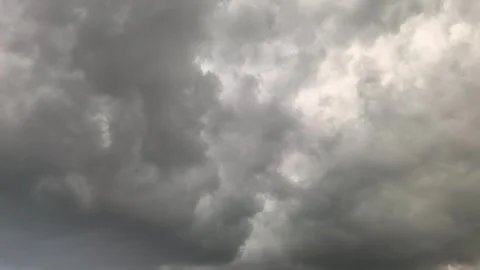Dark clouds gather over a city as a storm approaches in the evening sky with fla Stock Footage 335405919