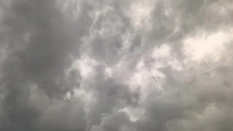 Dark clouds gather over a city as a storm approaches in the evening sky with fla Stock Footage 335405933