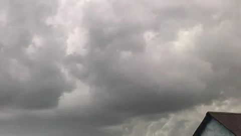 Dark clouds gather over a city as a storm approaches in the evening sky with fla Stock Footage 335406034