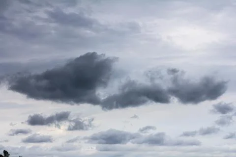 Dark clouds gather in a stormy sky over a tranquil landscape as nature prep.. Stock Photos