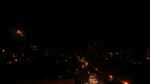 Dark clouds glow in the light of lightning over city traffic Stock Footage 171371786