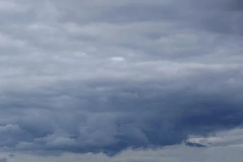 Dark clouds hung high in the Summer dark . Stock Photos