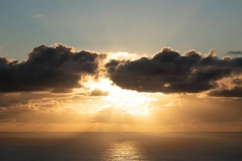 Dark clouds lit by bright sunset light Stock Photos