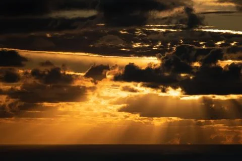 Dark clouds lit by bright sunset light Stock Photos