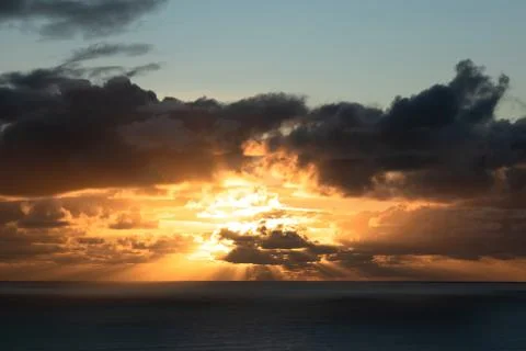 Dark clouds lit by bright sunset light Stock Photos