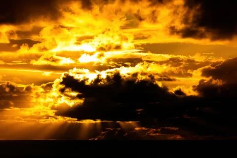 Dark clouds lit by bright sunset light Stock Photos