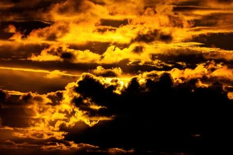 Dark clouds lit by bright sunset light Stock Photos