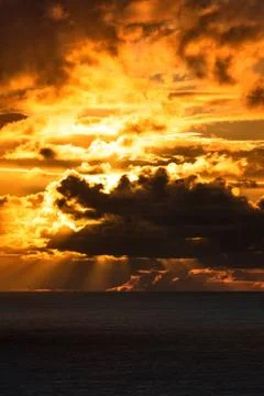Dark clouds lit by bright sunset light Stock Photos