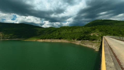 Dark clouds loom above the green hills. Zavoj Lake, Serbia Stock Footage 337493536