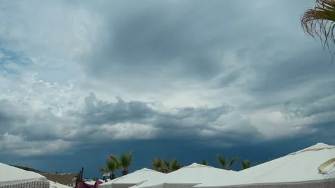 Dark clouds loom above white tents. Trani Ammouda, Greece Stock Footage 339618910