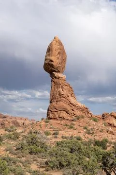 Dark clouds loom around Balanced Rock in Arches National Park in southern Uta Stock Photos