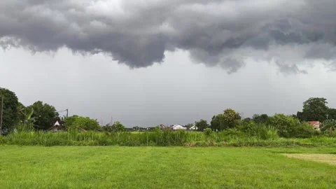 Dark clouds loom over a green field Stock Footage 342084872