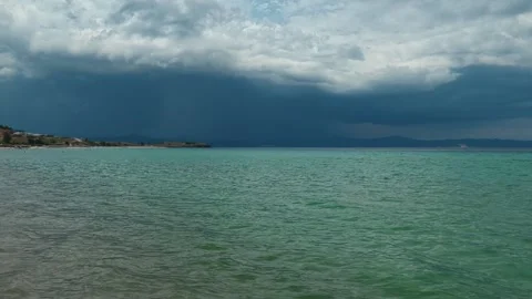 Dark clouds loom over turquoise waters. Trani Ammouda, Greece 스톡 동영상 339619610
