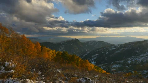 Dark clouds move over mountain and golden sapen fall trees Stock Footage 68330961