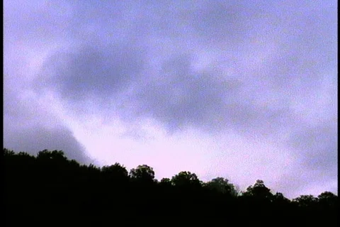 Dark clouds move rapidly over silhouette of tree line. Stock Footage 86752768