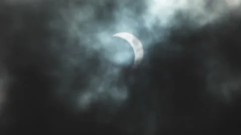 Dark clouds moving in front the moon shadow covered sun, a solar eclipse, Stock Footage 145444328