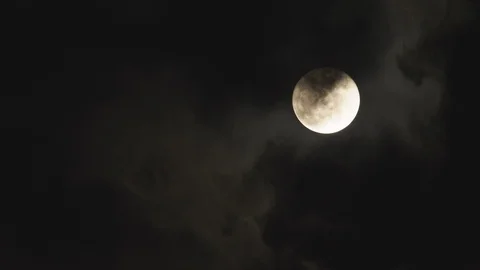 Dark clouds moving through the full moon at night Stock Footage 103785681