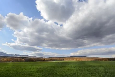 Dark clouds over the field and trees. Sky and field in the spring. Stock Photos