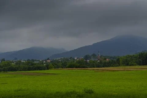 Dark Clouds over Meadow with Distant Church Stock Photos