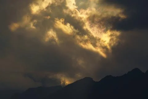 Dark clouds over mountain at sunset Stock Photos