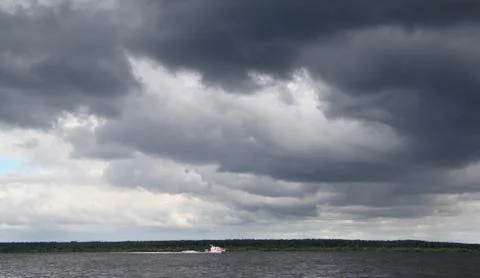 Dark clouds over the river Stock Photos