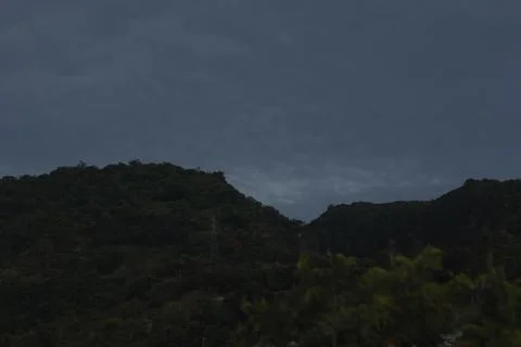 Dark Clouds Over Silhouetted Hill Stockfoto's