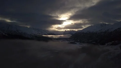 Dark clouds over the snow capped mountains ranges at dusk Stock Footage 104528949