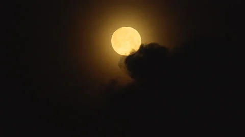 A dark clouds overlaps a full round moon on night sky Stock Footage 59697464