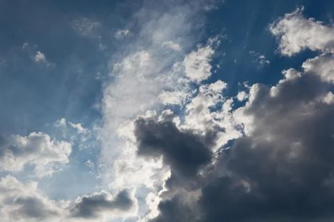 Dark clouds with rays of light shining Stock Photos