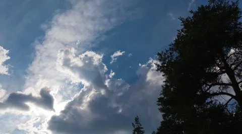 Dark clouds with rays of light shining Stock Photos