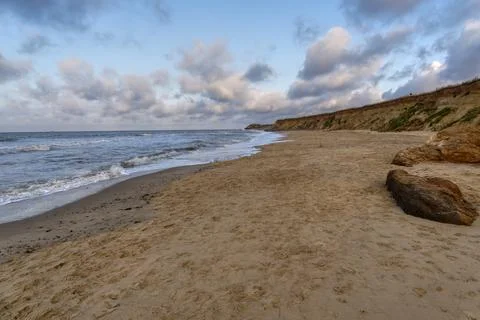 Dark clouds roll over the cliffs of Happisburgh beach Stock Photos