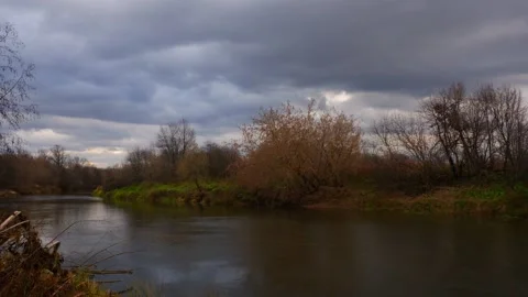 Dark clouds running over the river on an autumn day. Timelapse Stock Footage 163656418