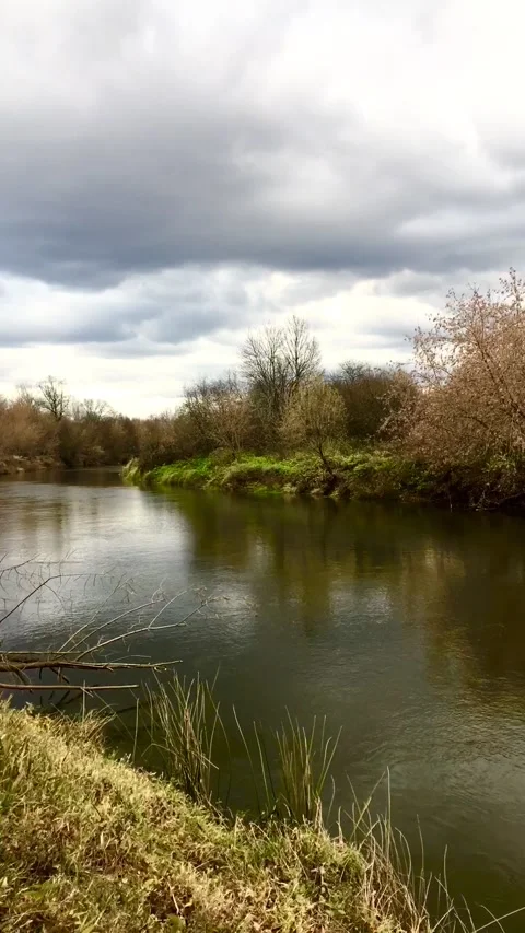 Dark clouds running over the river on an autumn day. Vertical video. Timelapse. Stock Footage 163671306