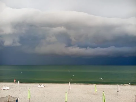 Dark clouds in the sky above the sea before the rain on the background of the Stock Photos