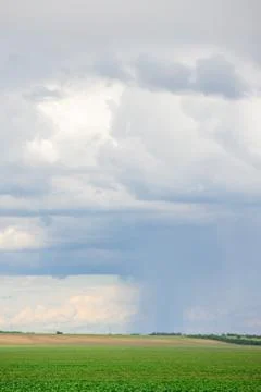 Dark clouds on sky with one part with rain over agricultural fields in distan Foto stock