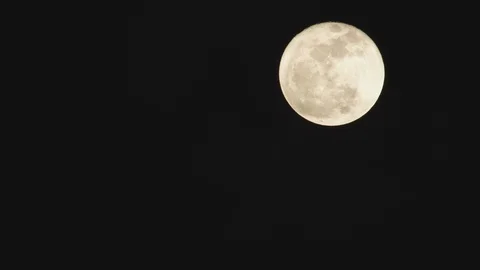 Dark clouds slowly moving past the full moon Stock Footage 103785189