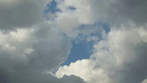 Dark clouds slowly take over the white cumulus in a blue sky, time lapse 77833242