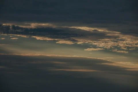 Dark clouds with soft light breaking through, creating a dramatic sky at du.. Stock Photos