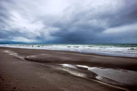 Dark clouds as a storm rolls across the sea towards the beach Stockfoto's