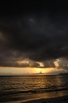 Dark clouds at sunset on the ocean Stock Photos