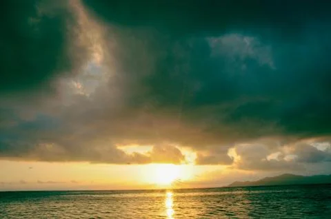 Dark clouds at sunset on the ocean Stock Photos