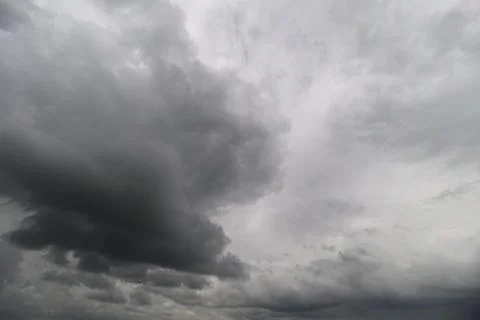 Dark clouds swirl and blend in the sky, hinting at a coming storm. The atmosp Stock Photos